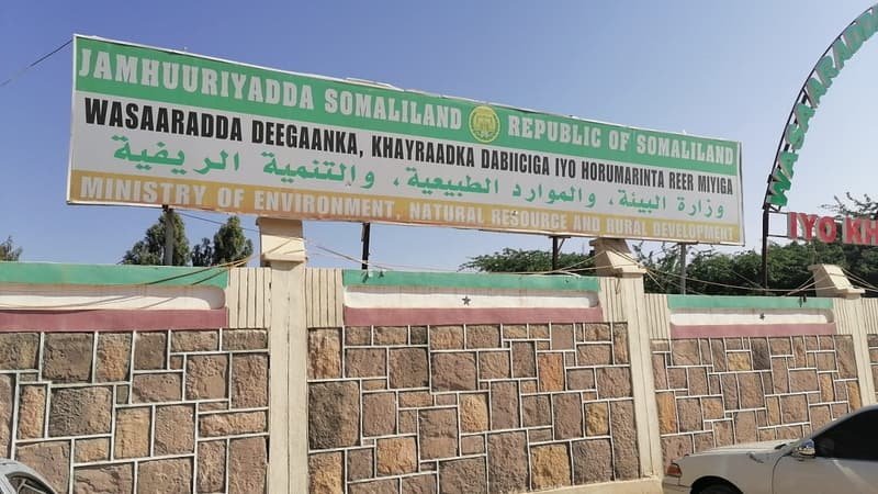 A government ministry board above a stone perimeter wall