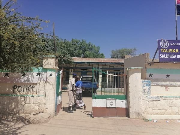 A police station frontage, a vehicle drawn up at the gate